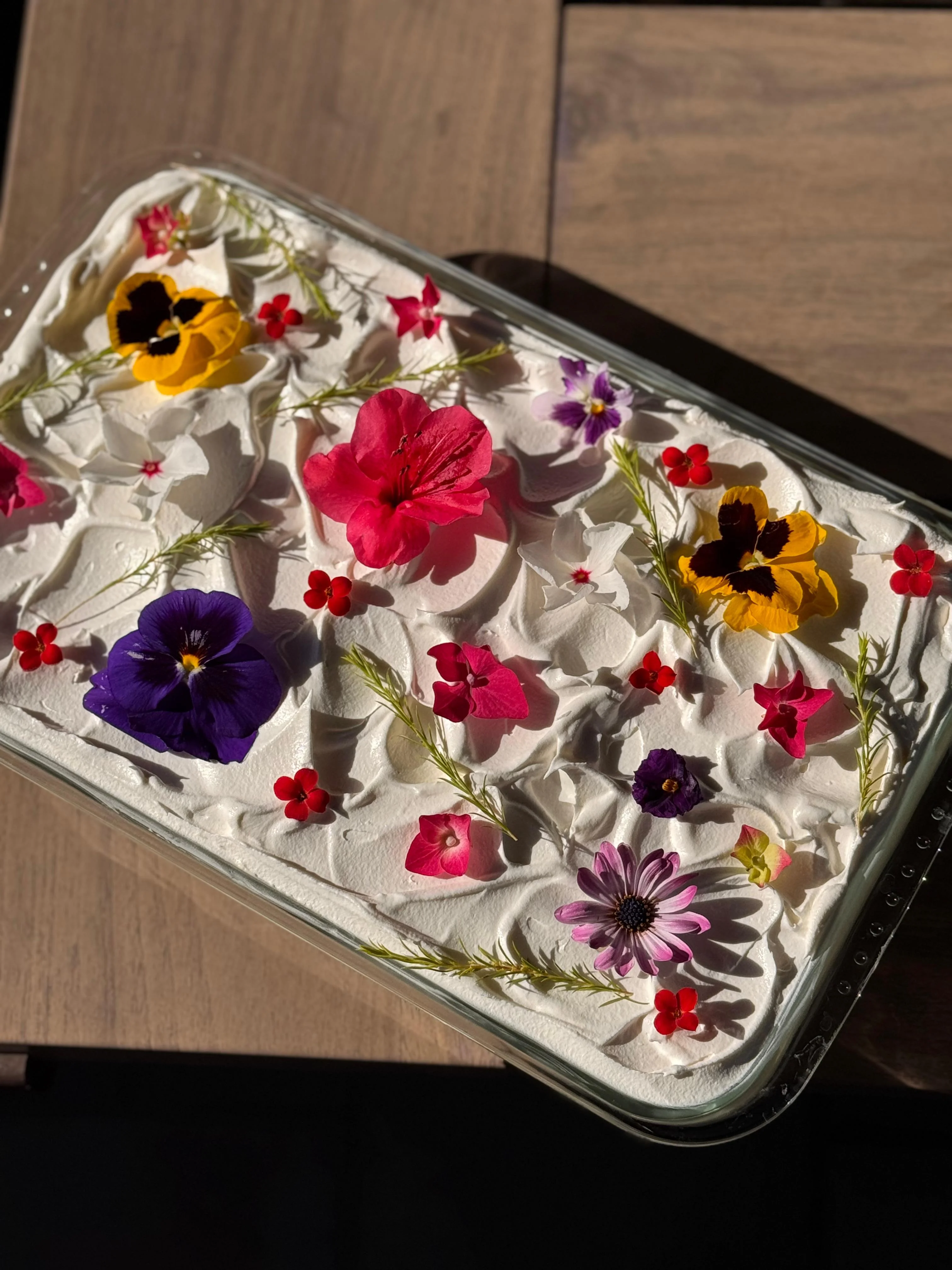 Jardin slab cake scattered with pansies, violas, geraniums, daisies and fresh herbs